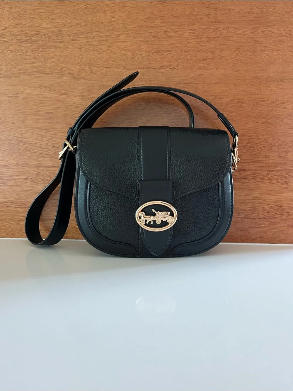 Coach Georgie crossbody saddle bag in black pebbled leather, gold tone hardware